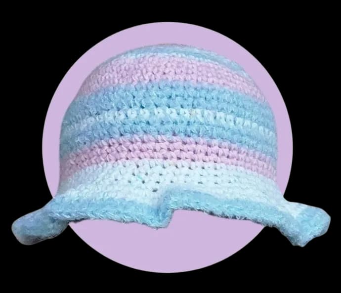 Bob au crochet à rayures pastel bleu ciel et lilas, vue de face sur fond violet clair