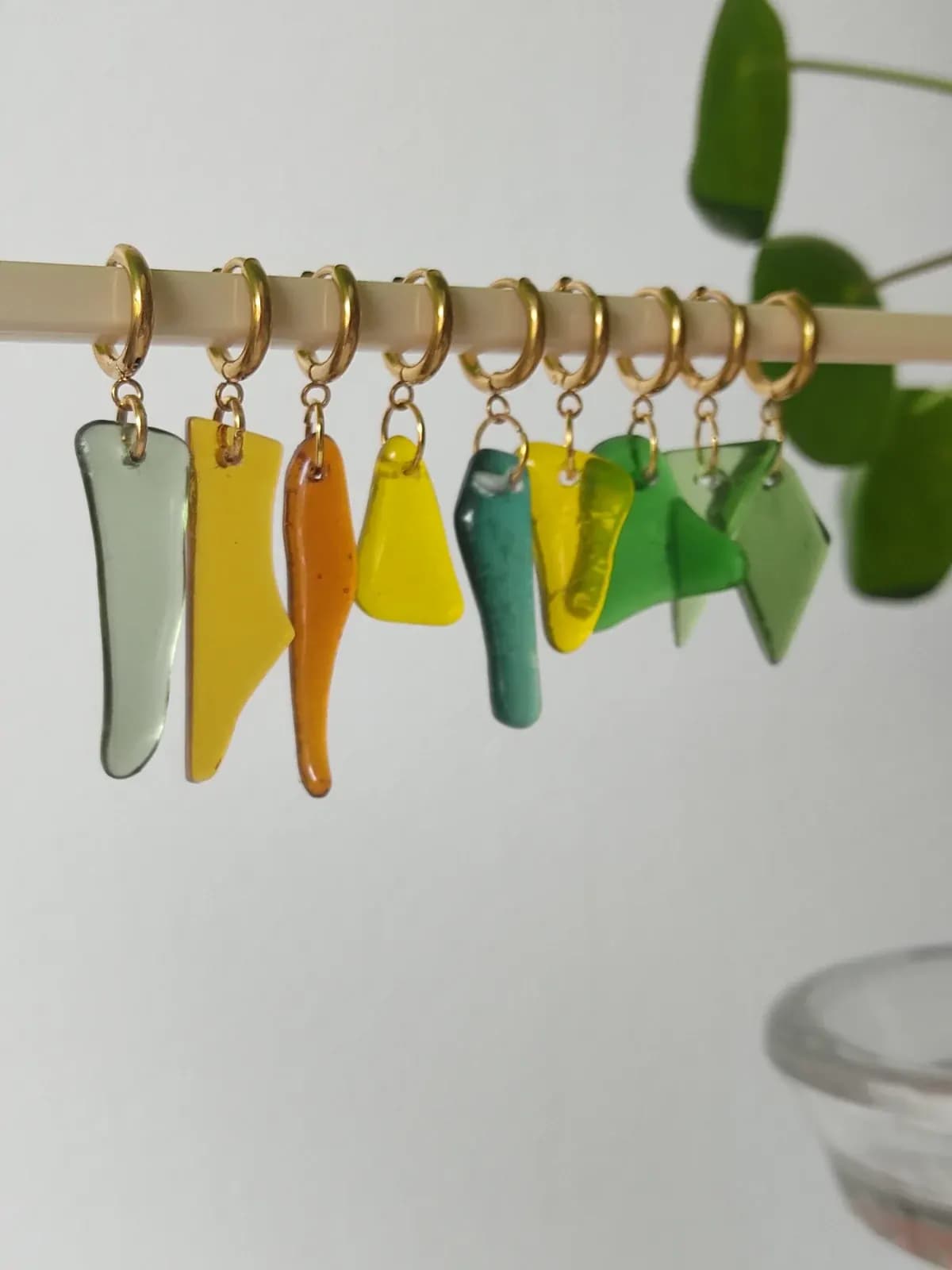 Assortiment de pièces en verre lisse multicolores percées pour la création de bijoux.