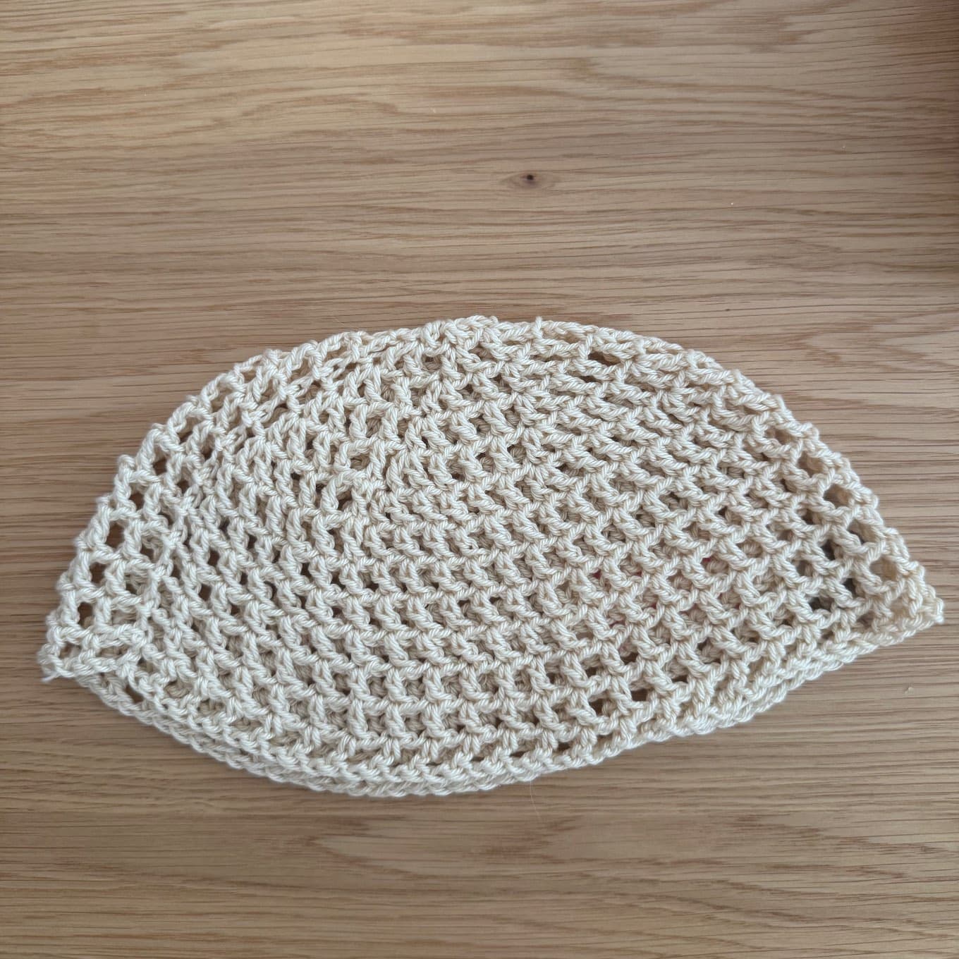 Portrait d'une femme avec lunettes de soleil coiffée du bonnet ajouré beige