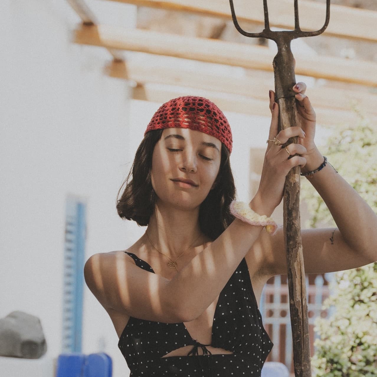 Femme portant un bonnet ajouré en maille claire et des lunettes de soleil au soleil