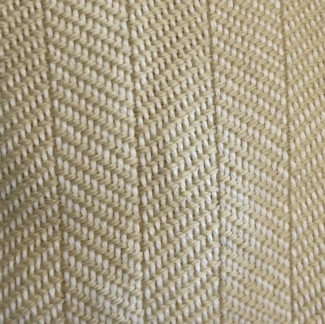 Gros plan sur le tissage chevron de l'écharpe artisanale blanc et champagne