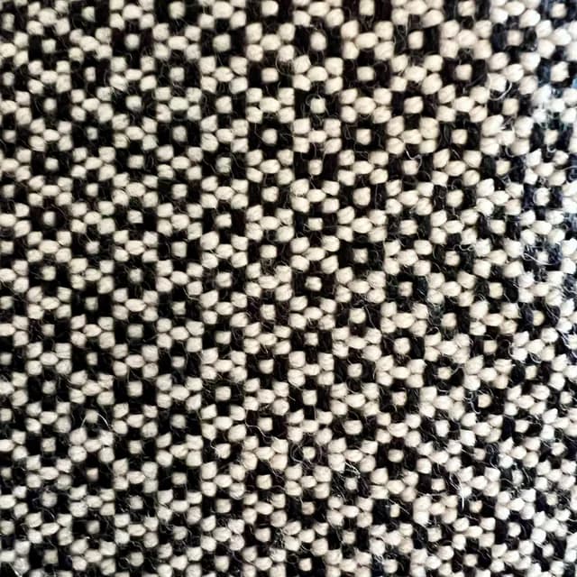 Détail du tissage artisanal noir et blanc et finitions avec franges nouées de l'écharpe.