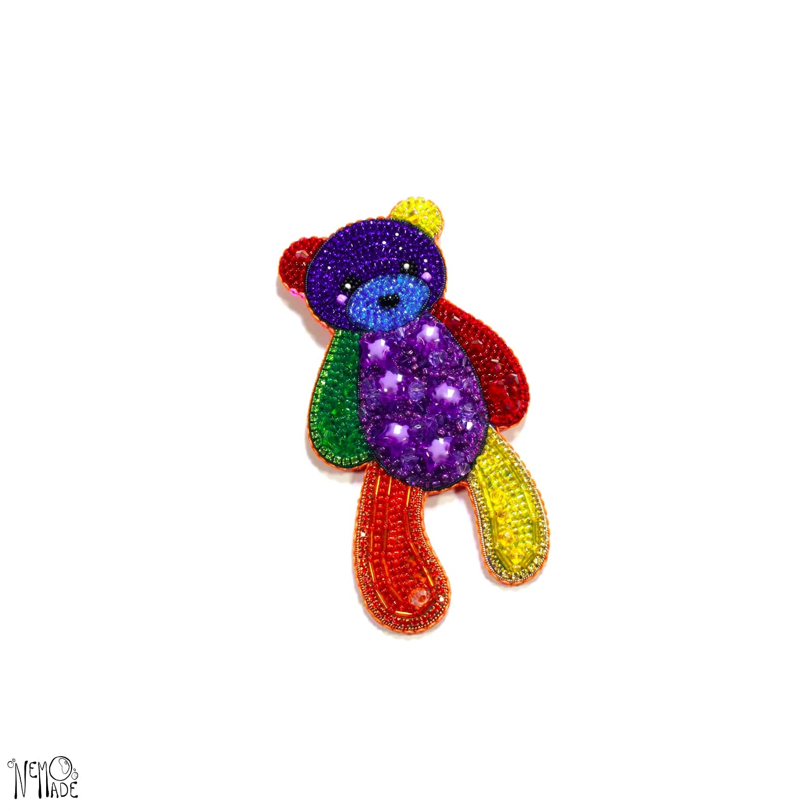 Broche en forme d'ourson brodée de perles multicolores sur fond blanc