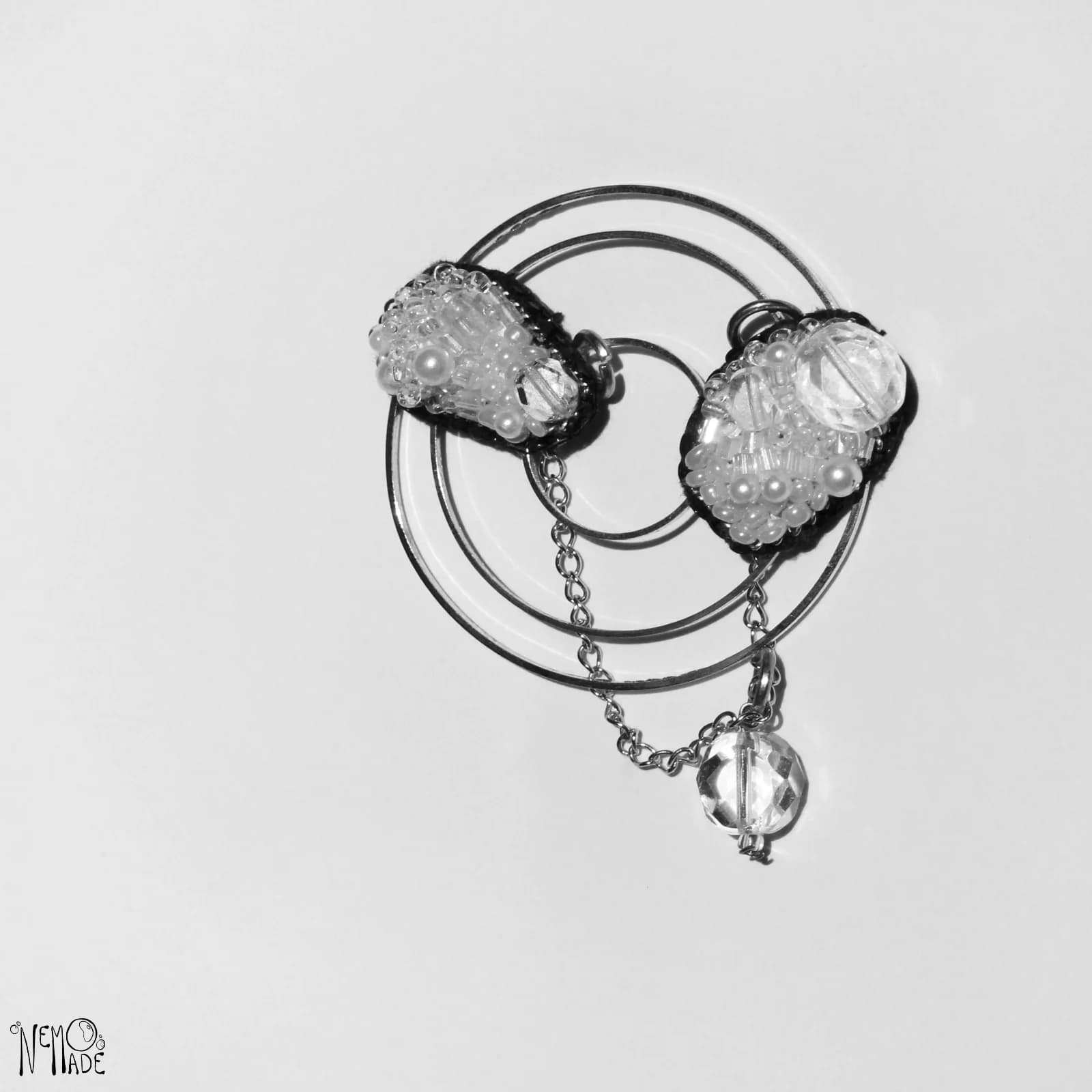 Pin double Météores en broderie perlée claire relié par une chaînette sur anneaux