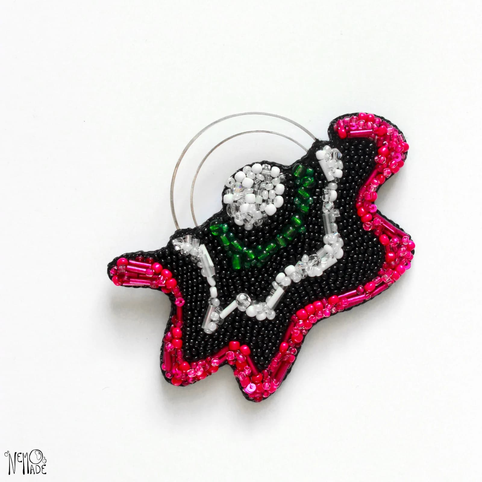 Broche Tinnitus brodée de perles noires et rose fuchsia avec détails blancs, verts et fil métallique courbé
