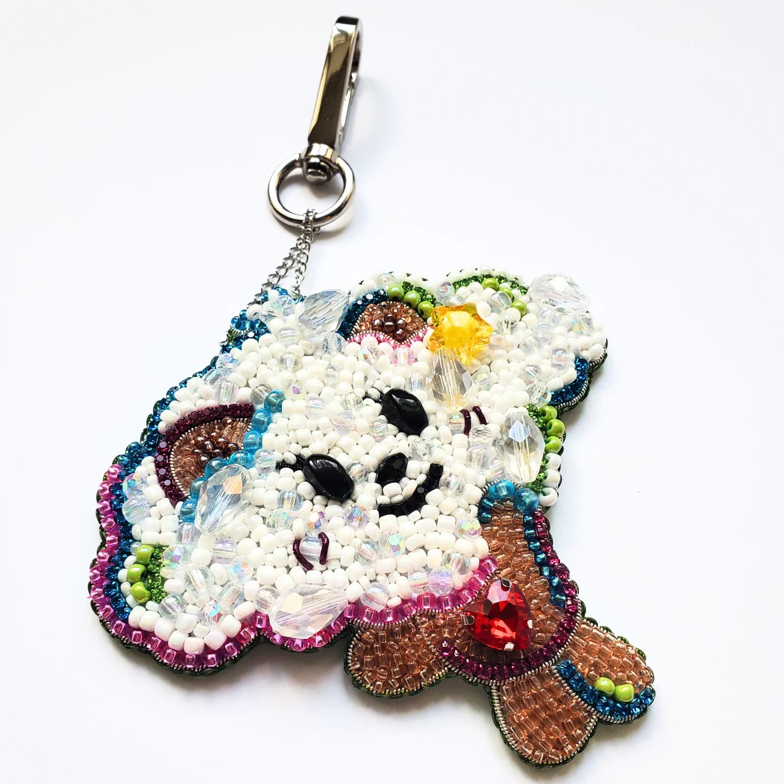 Porte-clé BAMGEUT brodé de perles blanches, sequins et détails multicolores avec mousqueton argenté.