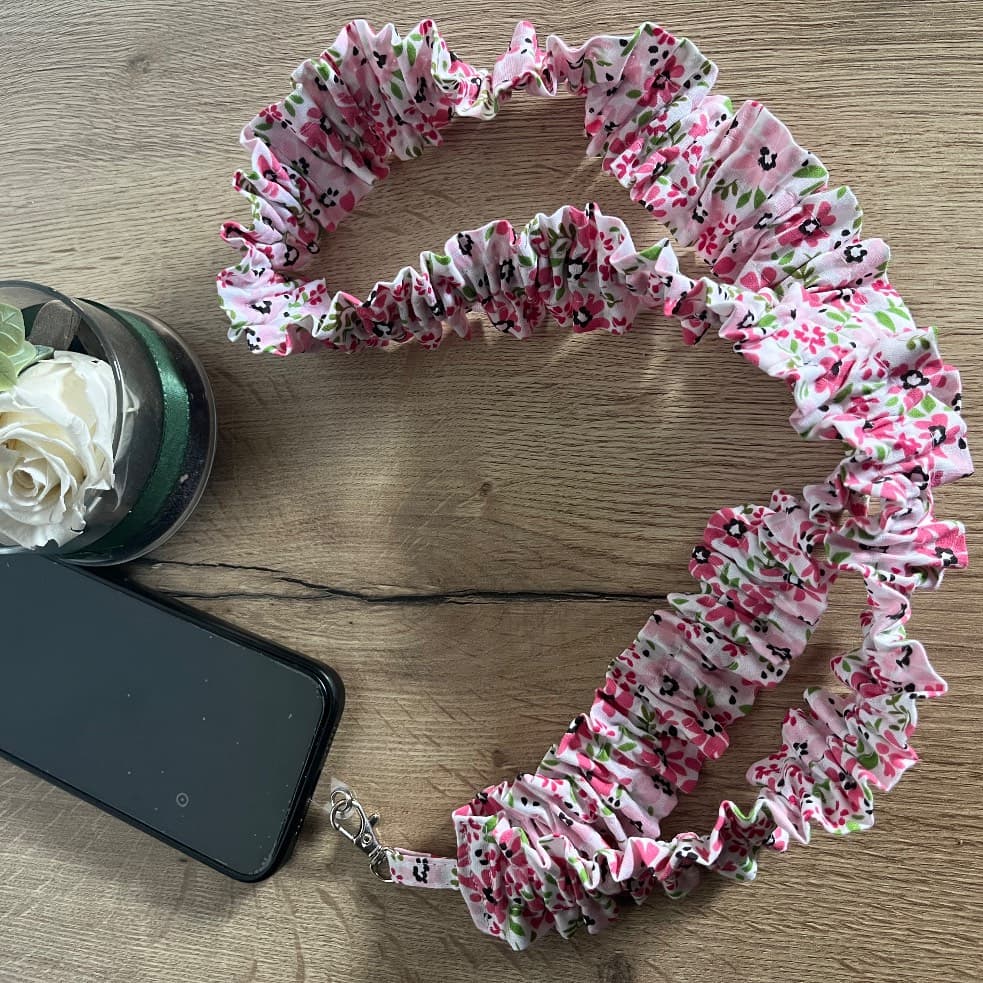 Bandoulière de téléphone froncée à motif fleuri rose