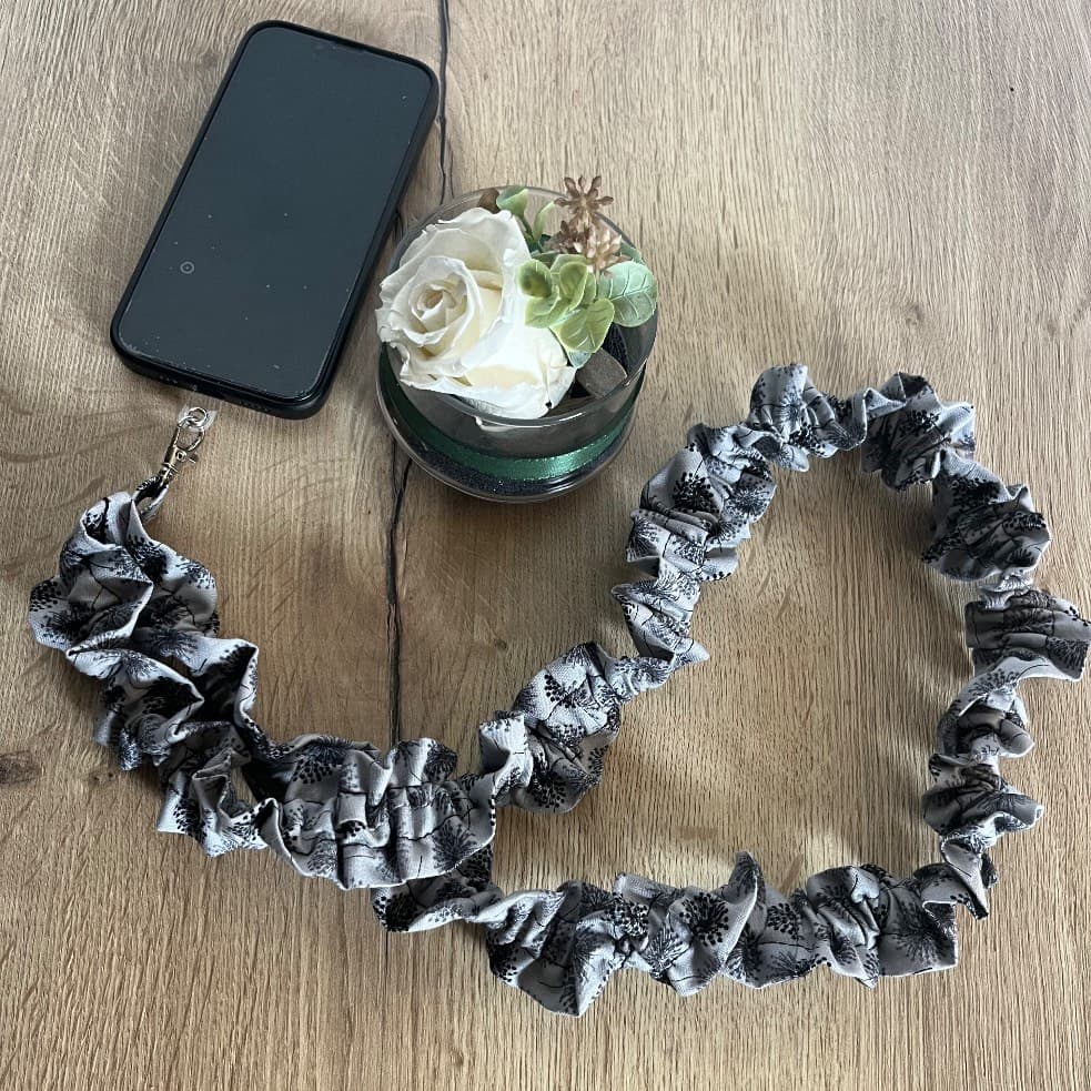 Bandoulière de téléphone froncée en tissu gris à motifs pissenlits