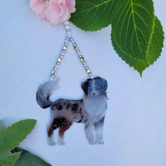 Attrape-soleil en forme de chien merle pailleté suspendu par un rang de perles et d'étoiles dorées