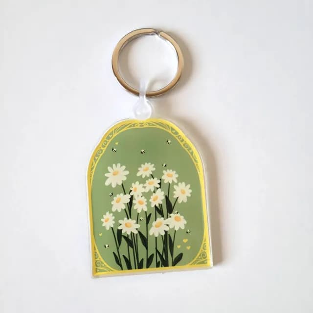 Détail du porte-clés illustré de pâquerettes blanches avec anneau métallique