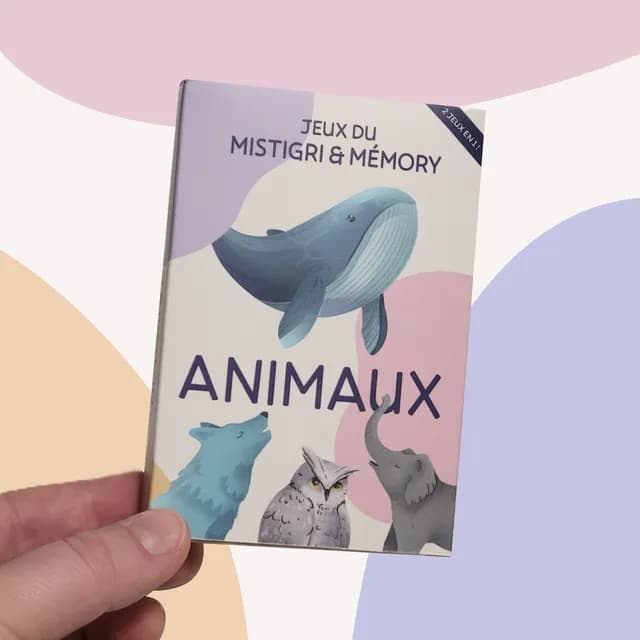 Boîte du jeu Mistigri et Memory Animaux tenue en main, illustrée d'une baleine, d'un loup et d'un hibou