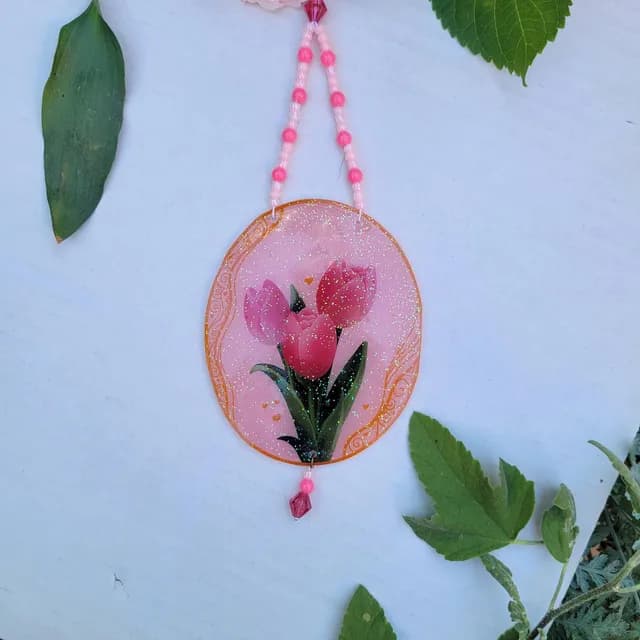Vue d'ensemble du suncatcher floral suspendu montrant les perles et le médaillon ovale