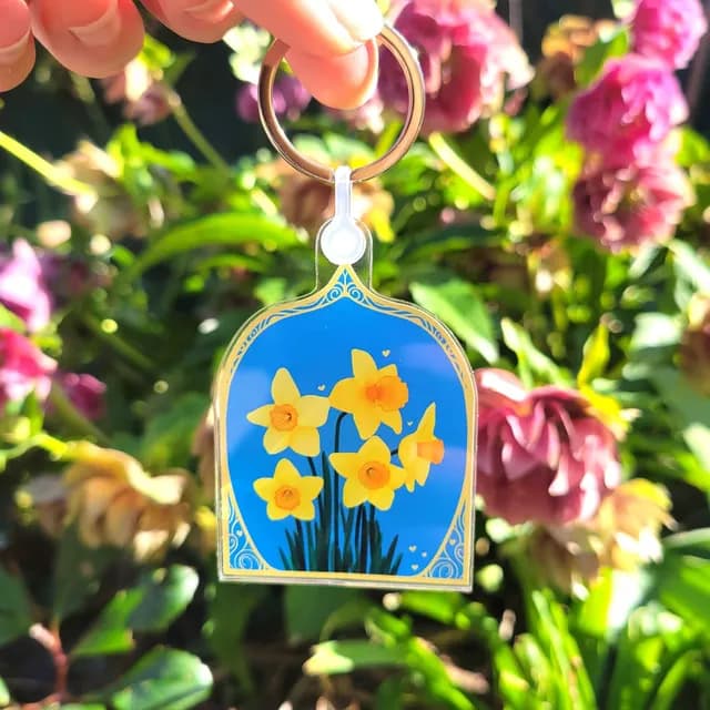 Porte-clés en acrylique jonquilles vu sous un autre angle mettant en avant sa transparence.
