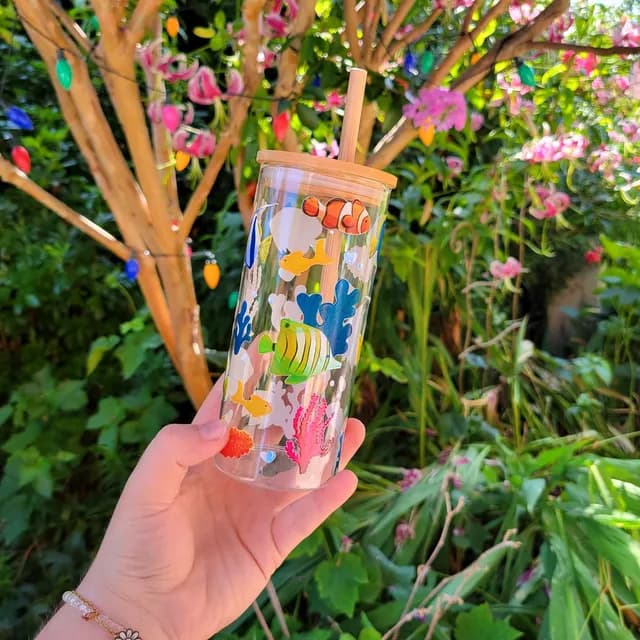Verre illustré de motifs marins colorés avec son couvercle en bambou et sa paille.
