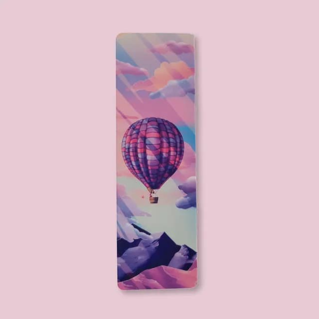 Illustration de montgolfière violette et rose dans un ciel aux nuages colorés sur marque-page.