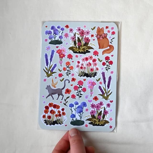 Planche d'autocollants sous blister avec motifs de fleurs colorées, lavande et chats.