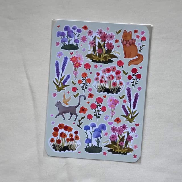 Détail des motifs illustrés d'autocollants aux teintes violettes, roses et orangées.