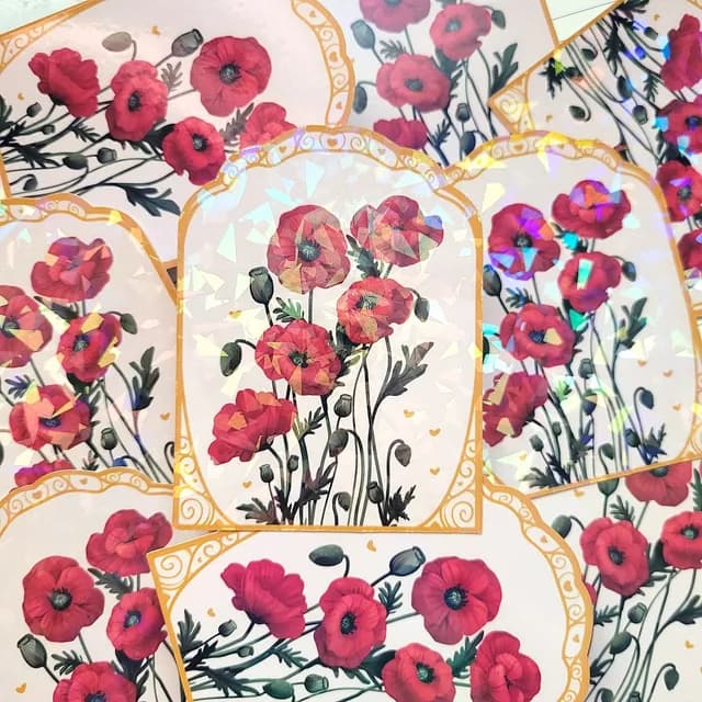 Gros plan sur le sticker aux fleurs de coquelicot et ses finitions holographiques