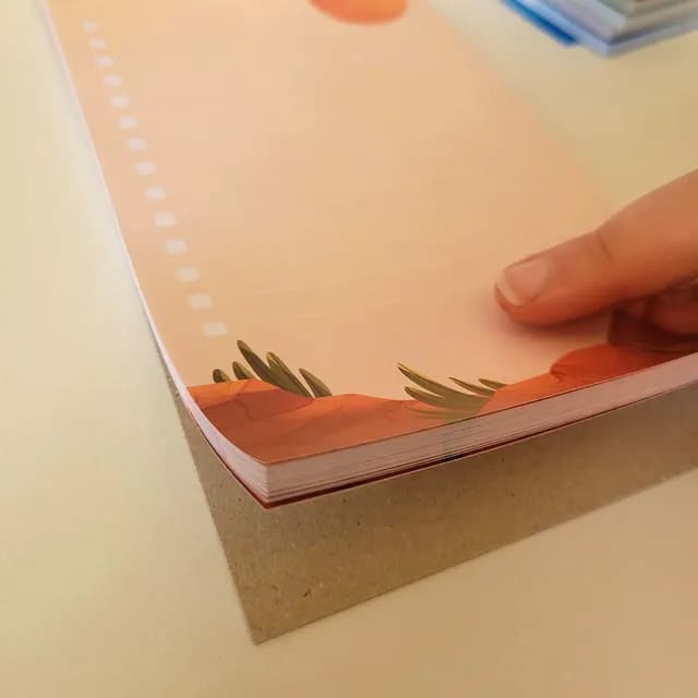 Vue du bloc-notes aimanté to-do list avec cases à cocher et décor de désert en bas de page.