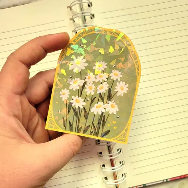 Autocollant pâquerette montrant ses effets holographiques lumineux et ses détails floraux.
