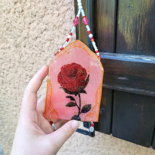 Gros plan sur l'illustration de la rose rouge avec reflets scintillants et finition résine UV