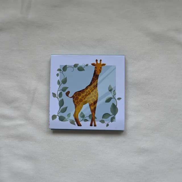 Bloc-notes carré illustré d'une girafe entourée de feuillage vert sur fond bleu clair