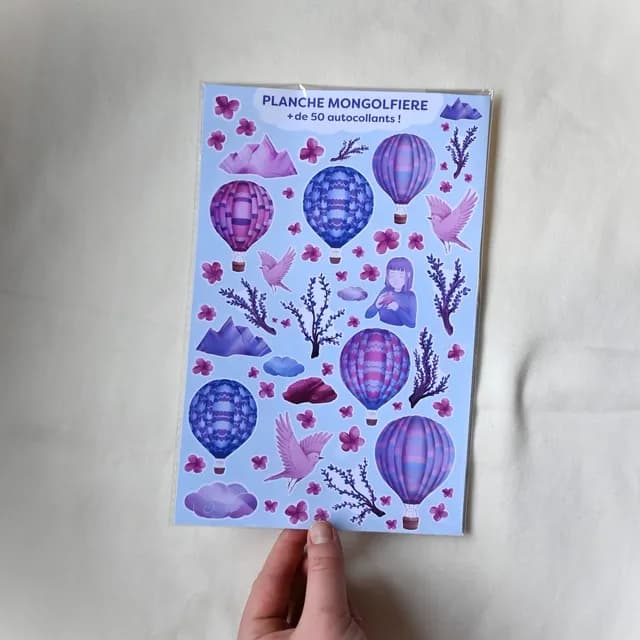 Grande planche sous blister d'autocollants montgolfières, oiseaux et fleurs dans les tons violets et bleus.