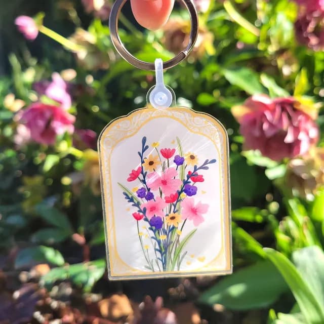 Porte-clés acrylique illustré d'un bouquet de fleurs colorées avec anneau métallique doré
