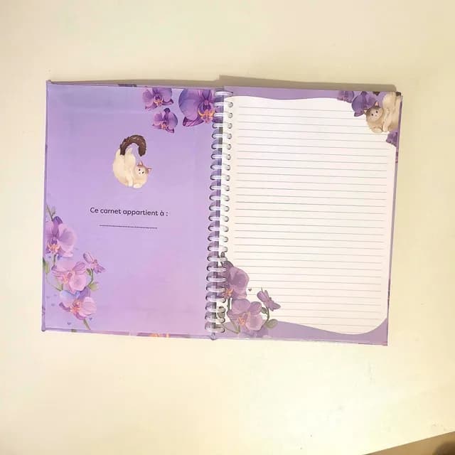 Couverture du carnet A5 aux teintes lilas représentant un chat blanc et de grandes fleurs d'orchidées