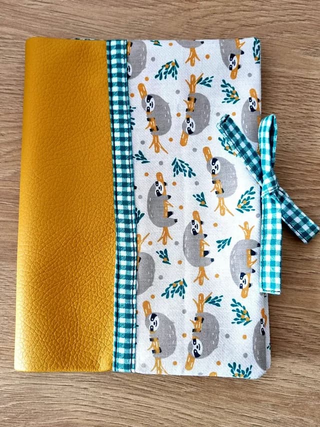 Protège-carnet de santé fermé en tissu paresseux et simili cuir jaune avec nœud à carreaux vichy verts.