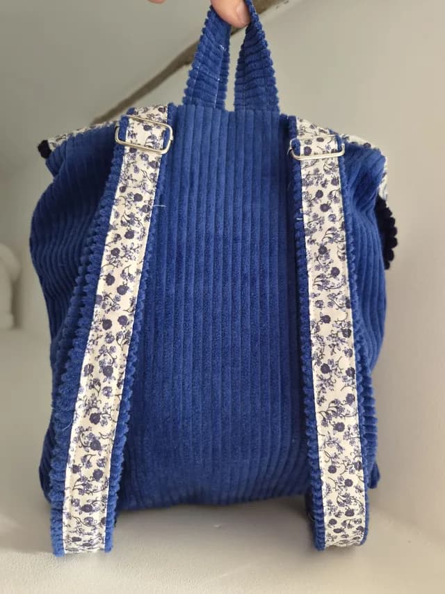 Vue d'ensemble du petit sac à dos en velours bleu et tissu fleuri pour la maternelle