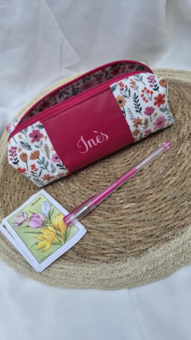 Trousse ouverte à motifs floraux et simili rose fuchsia personnalisée avec le prénom Inès.