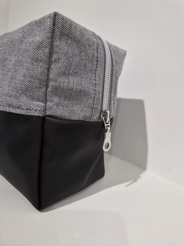 Vue de face de la trousse de toilette bicolore grise et noire fait main