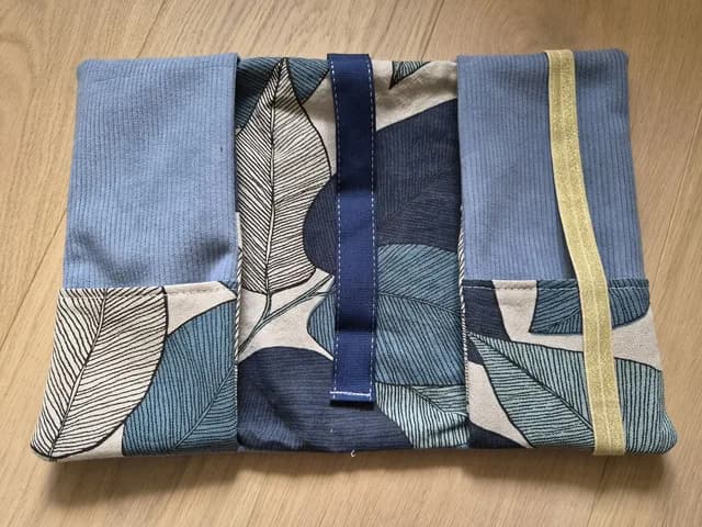 Pochette à livre en velours côtelé bleu et tissu à motif feuillage vue de face.