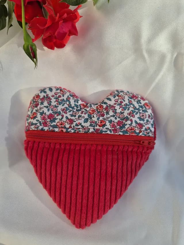 Pochette en forme de cœur en velours côtelé rouge et tissu fleuri liberty, avec fermeture éclair rouge.