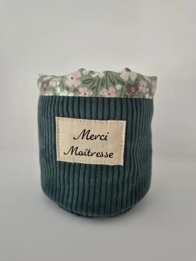 Pot à crayons en velours côtelé vert avec étiquette Merci Maîtresse et revers à motifs fleuris.