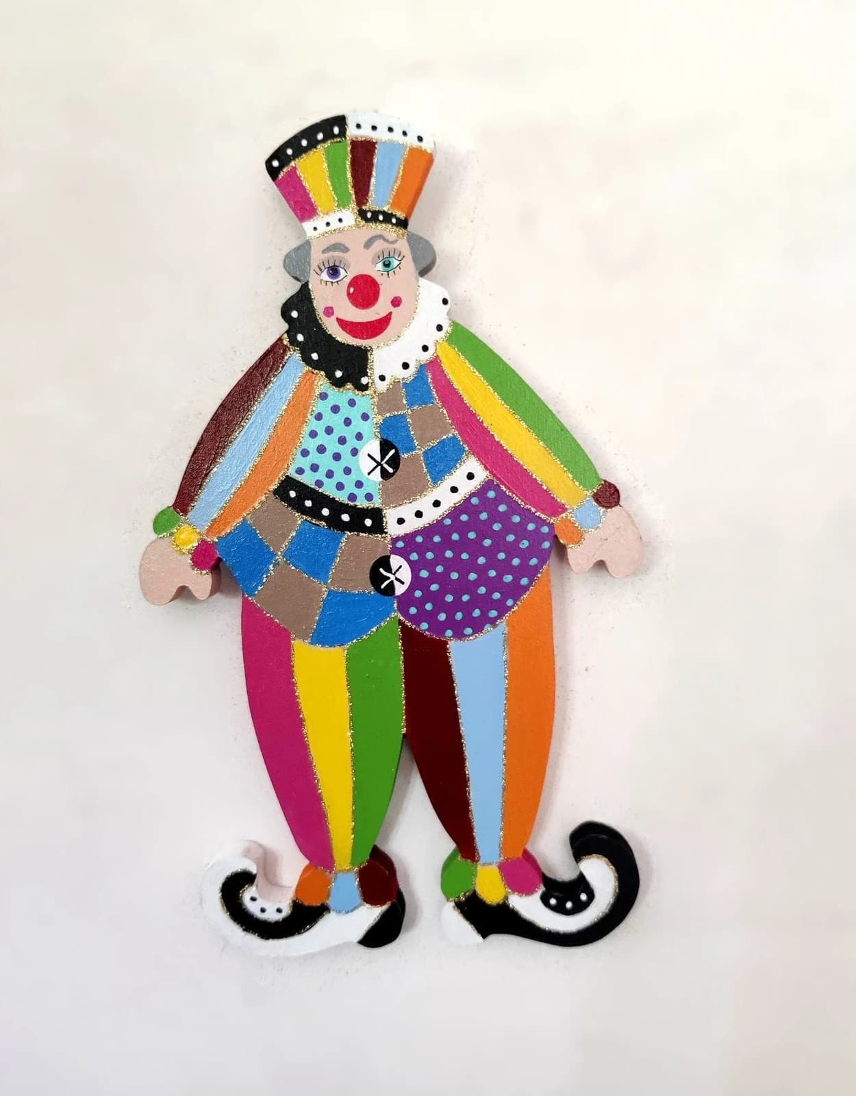 Clown mural en bois peint de motifs asymétriques multicolores, à pois et rayures avec chapeau haut