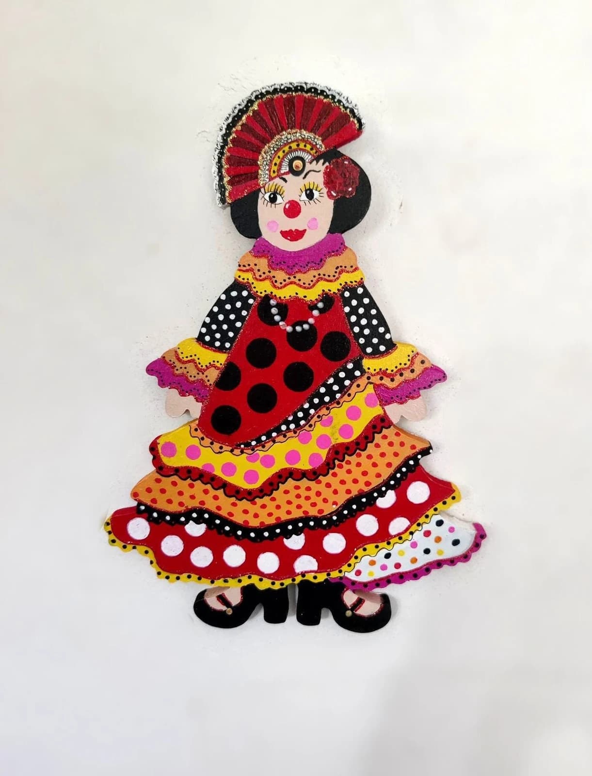 Clown mural en bois représentant une danseuse à robe à volants colorés à pois et coiffe éventail.