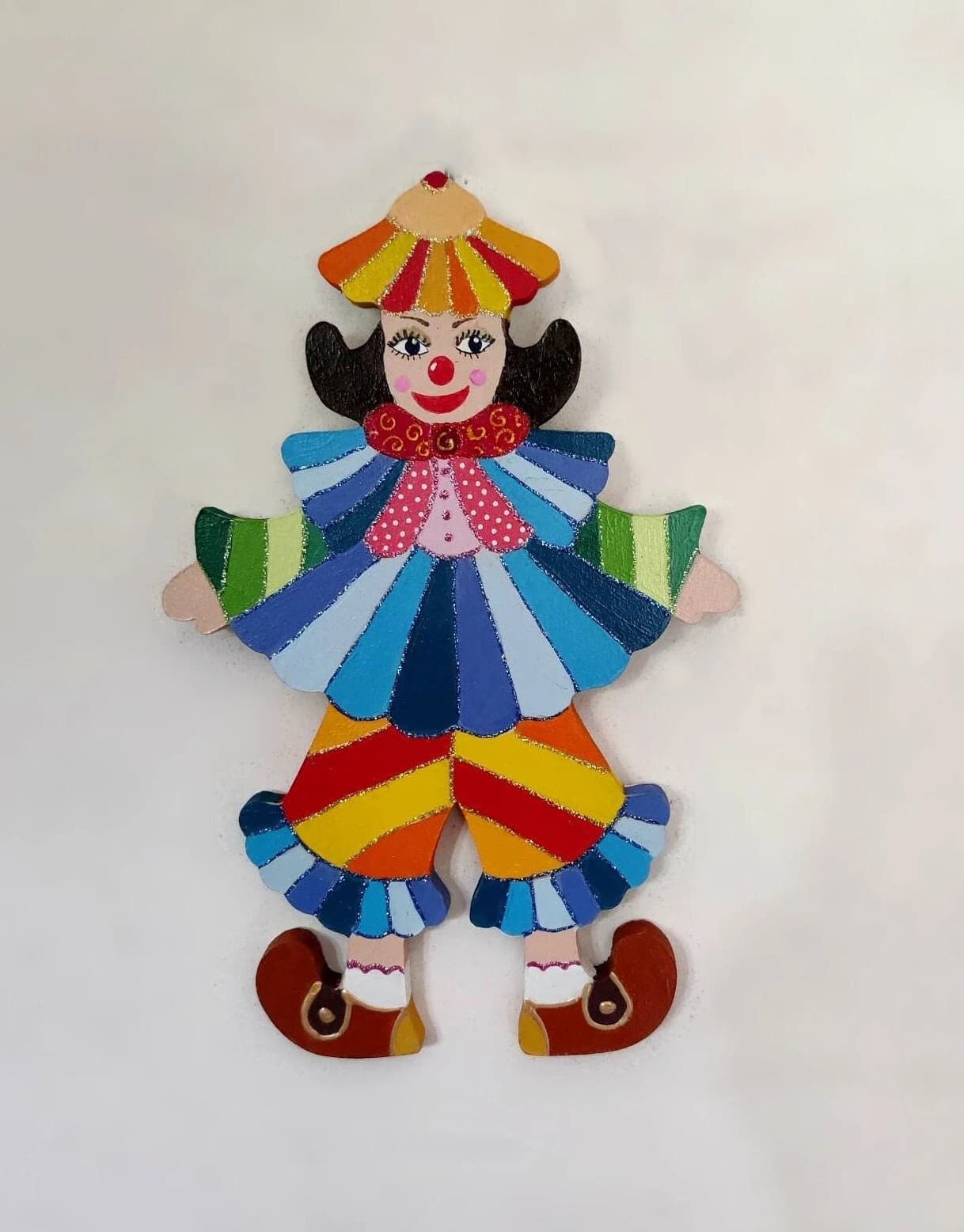 Clown mural en bois peint à la main avec chapeau jaune et rouge, collerette bleue et pantalon rayé.