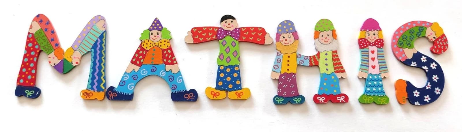 Détail de lettres décoratives peintes en forme de clowns acrobatiques colorés.