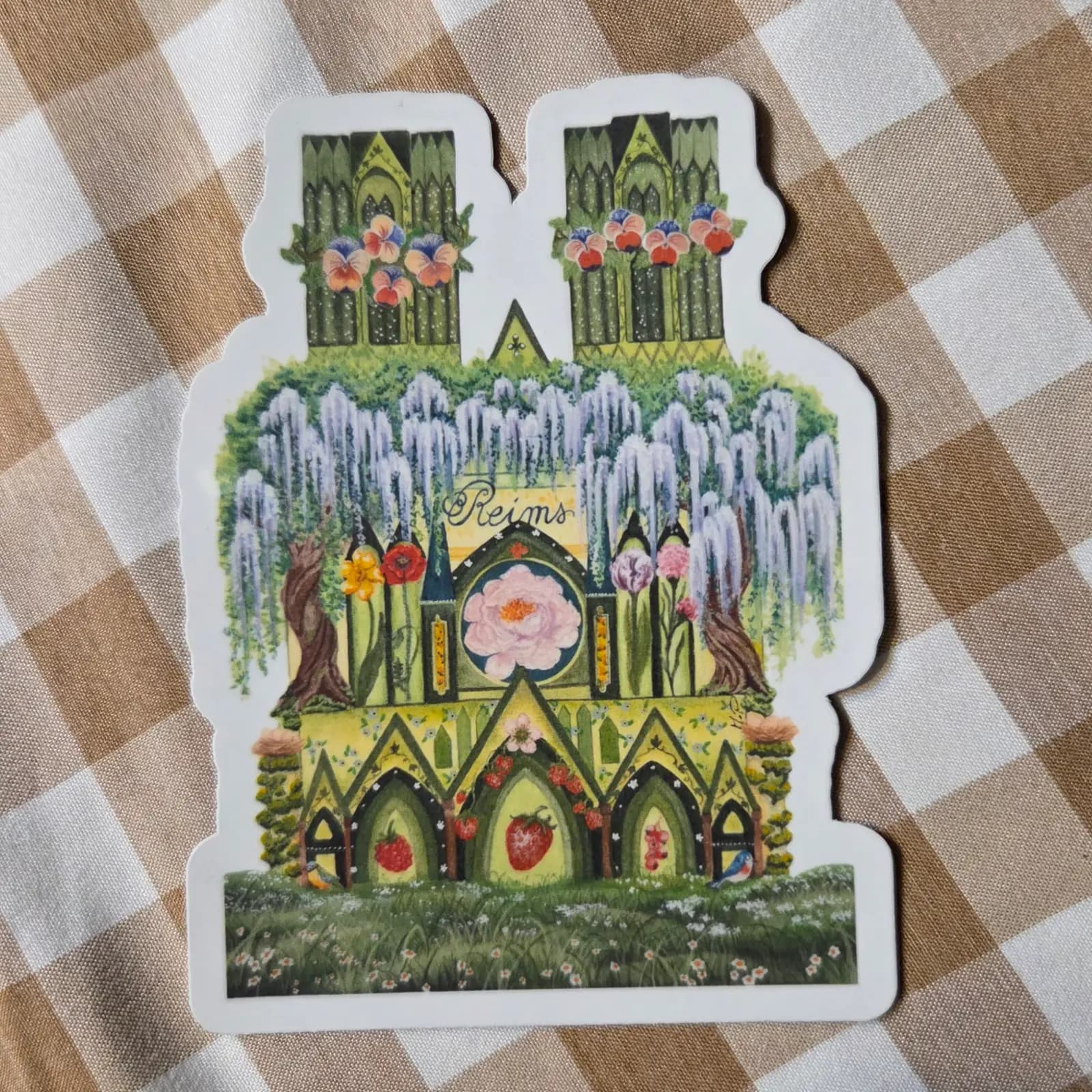 Sticker découpé de la cathédrale de Reims illustrée de glycines, pensées et fraises dans les tons verts.