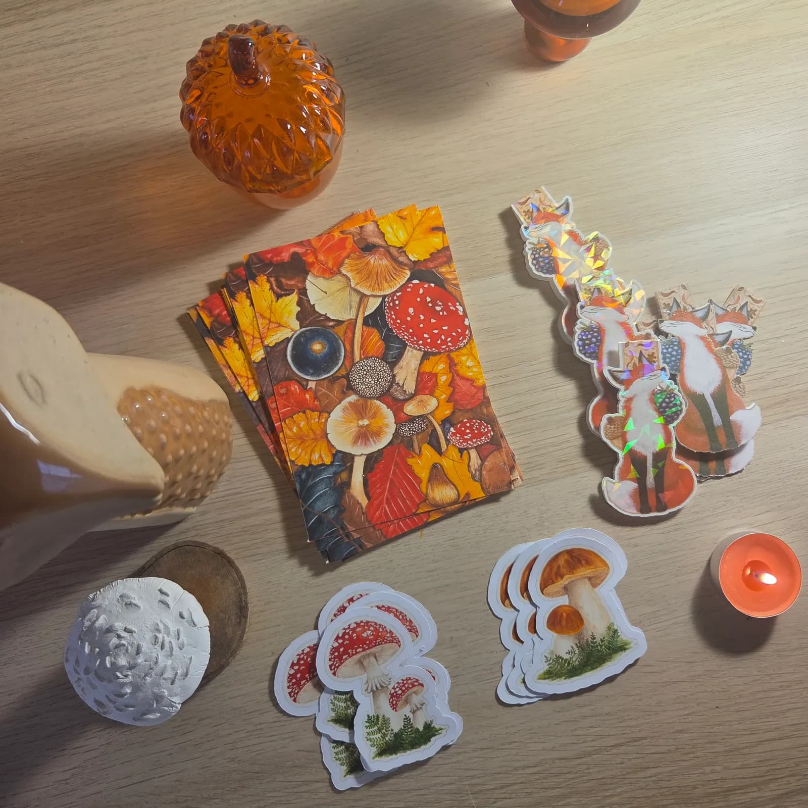 Ensemble papeterie d'automne avec tirage A6, stickers champignons et marque-pages renard sur fond boisé.