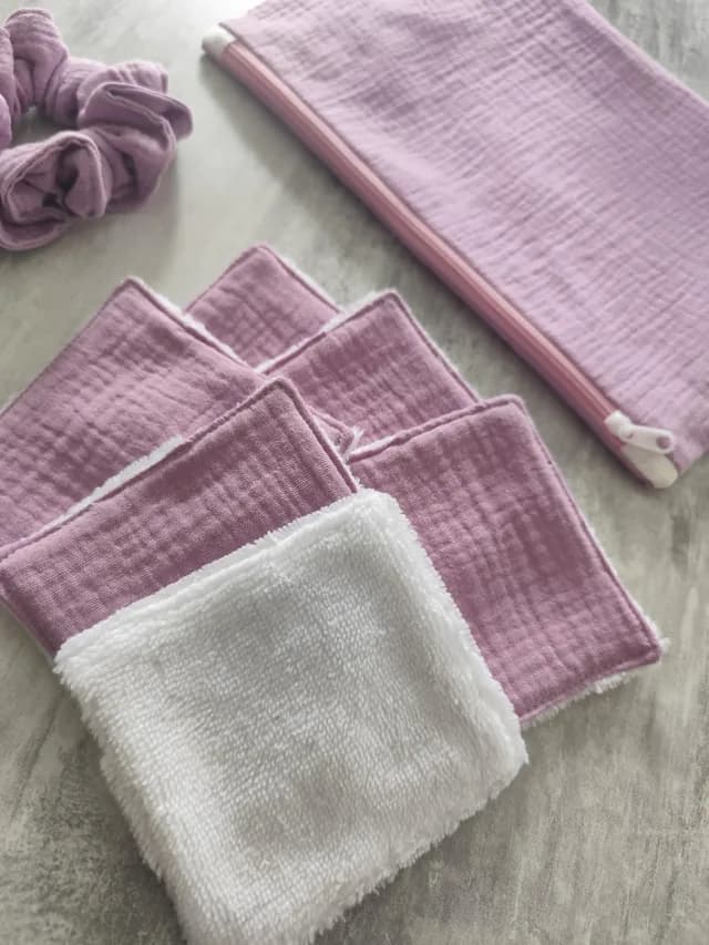 Ensemble textile mauve composé d'une pochette zippée, d'un chouchou et de lingettes réutilisables.