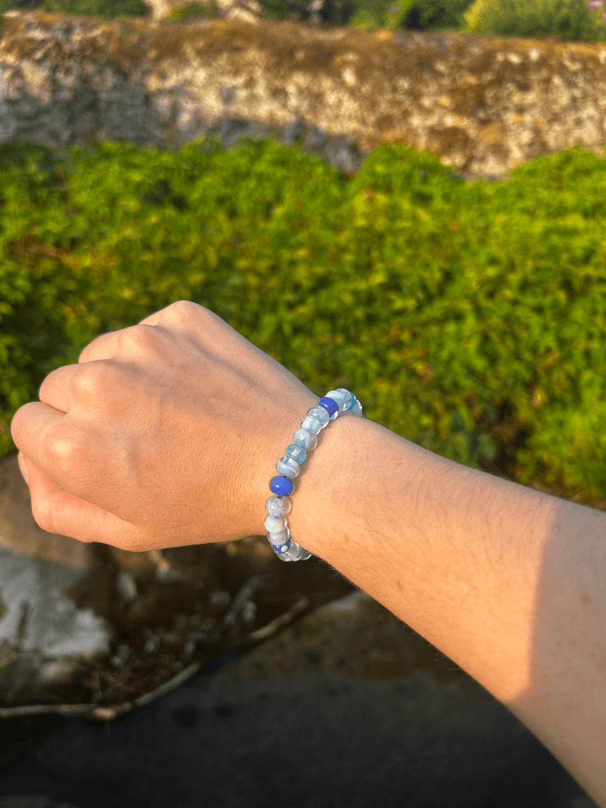 Bracelet artisanal en perles de verre aux nuances bleues porté au poignet