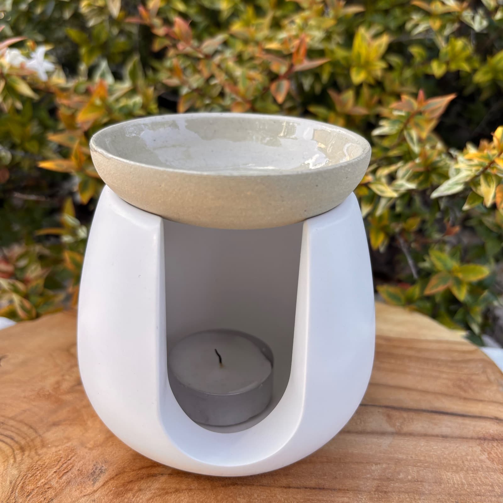 Diffuseur blanc aux formes arrondies avec coupelle en grès clair et bougie chauffe-plat.