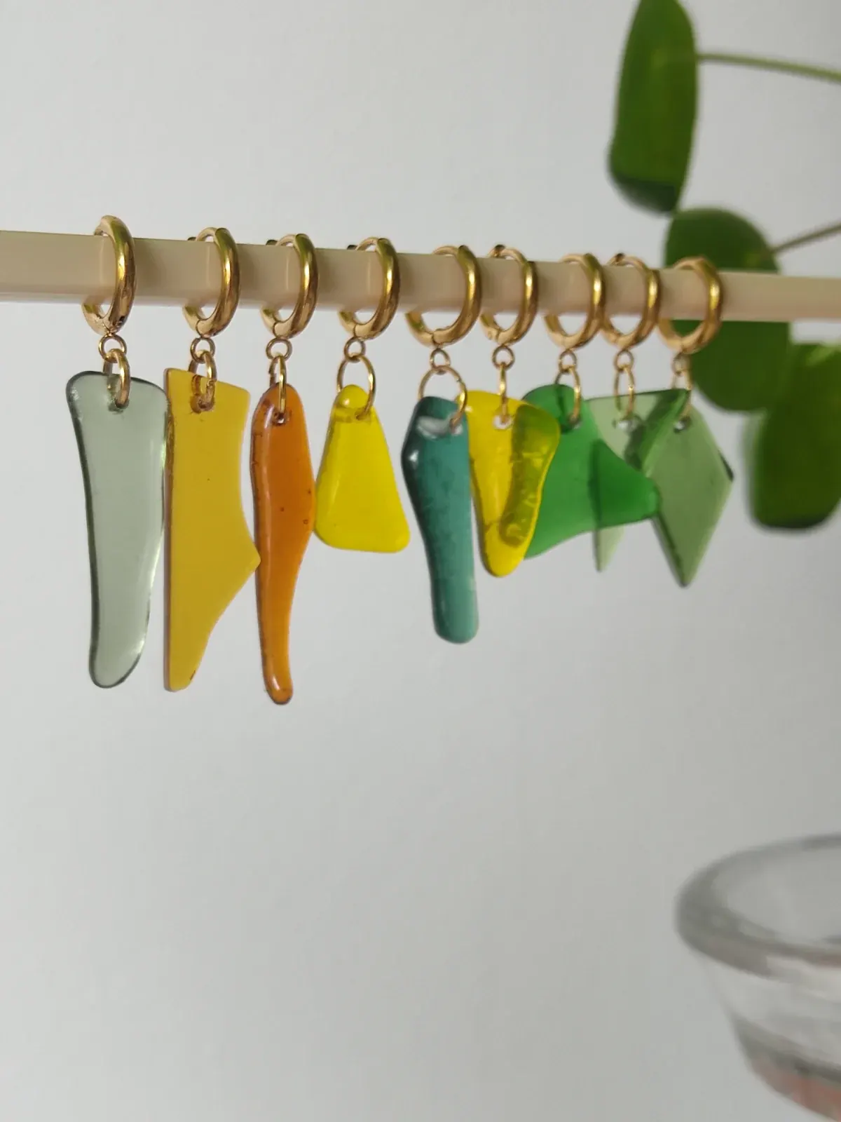 Assortiment de pièces en verre lisse multicolores percées pour la création de bijoux.