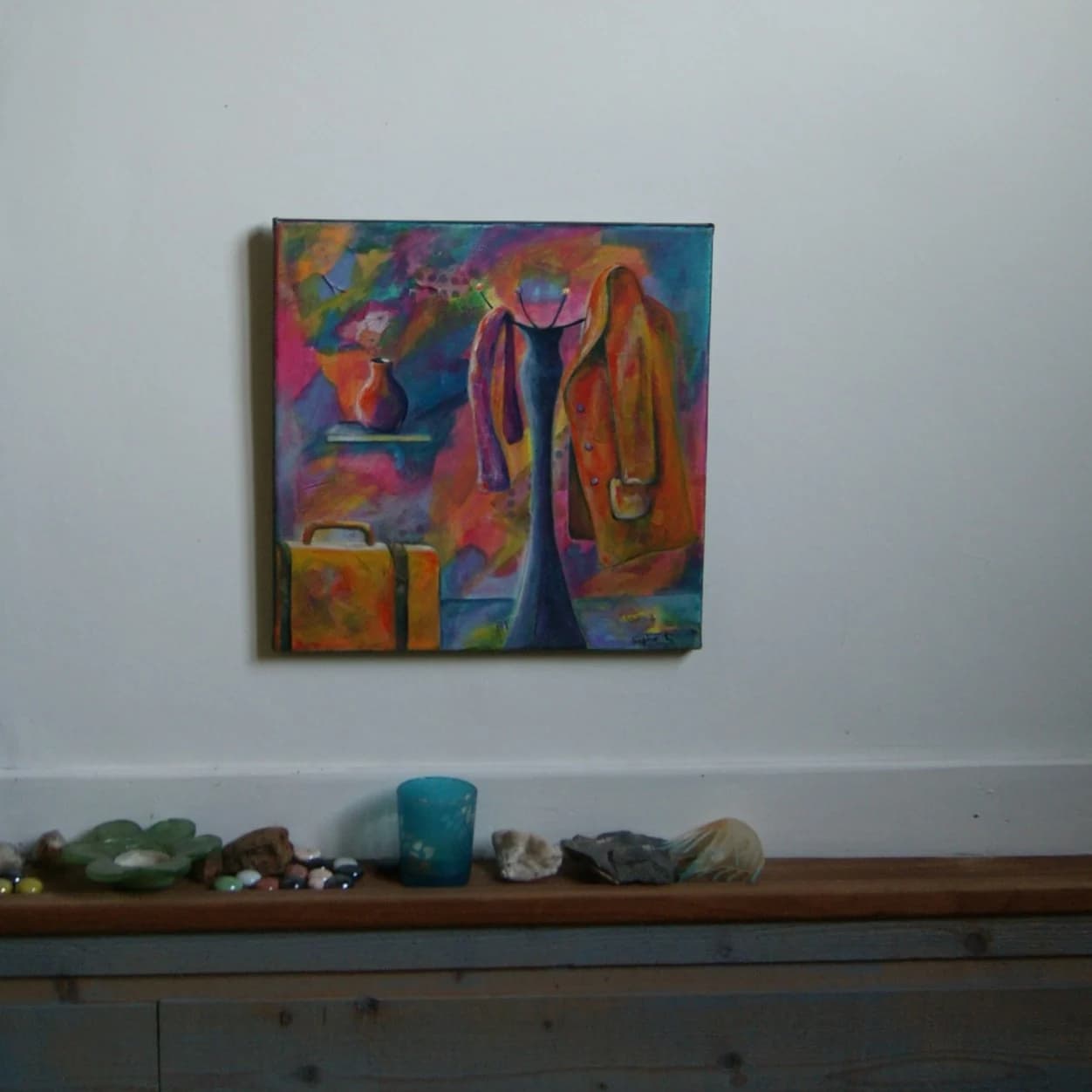 Tableau représentant un porte-manteau avec manteau orangé, une valise jaune et un vase sur fond multicolore.