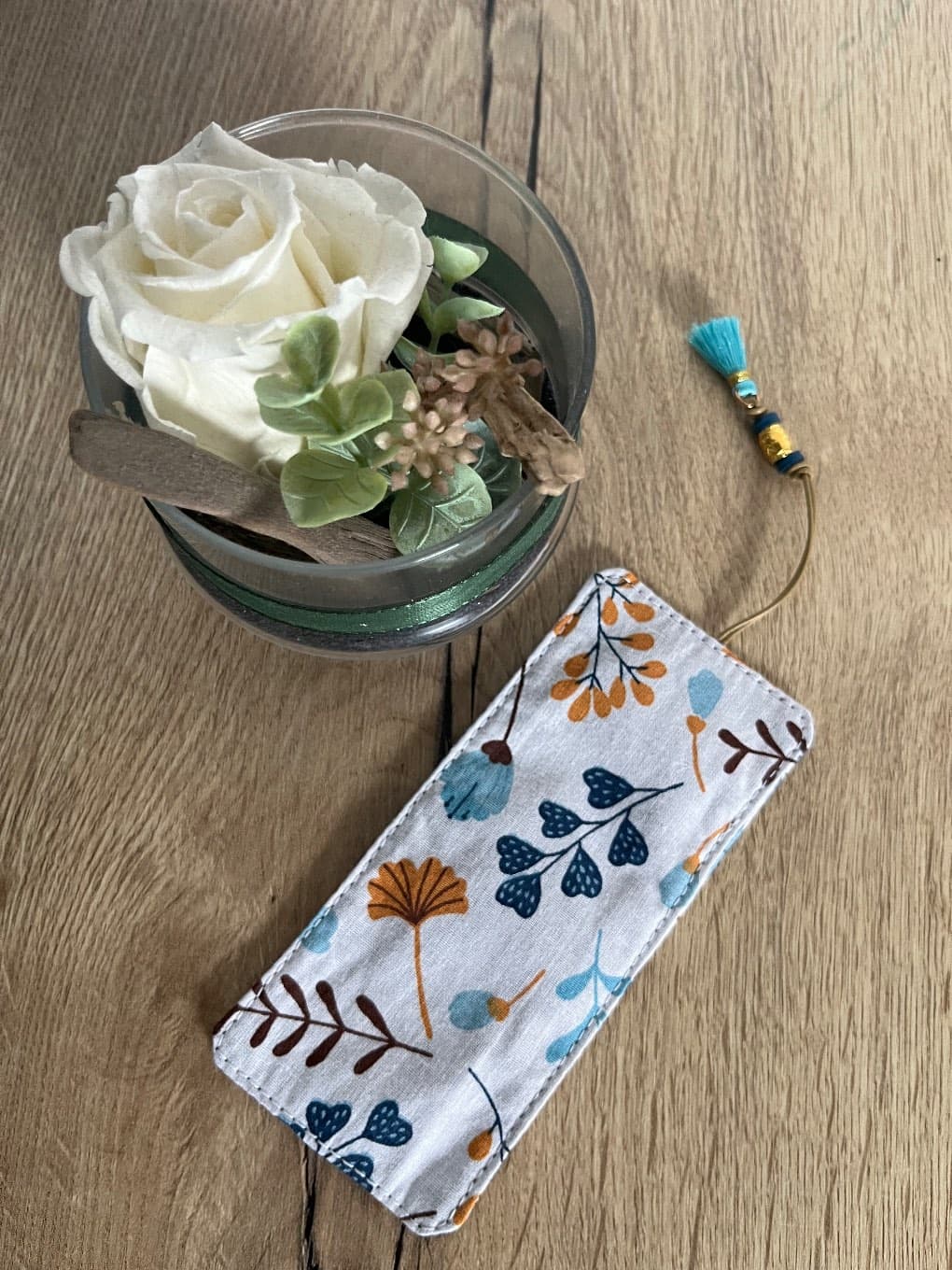 Marque-page en tissu à motifs végétaux et pompon bleu