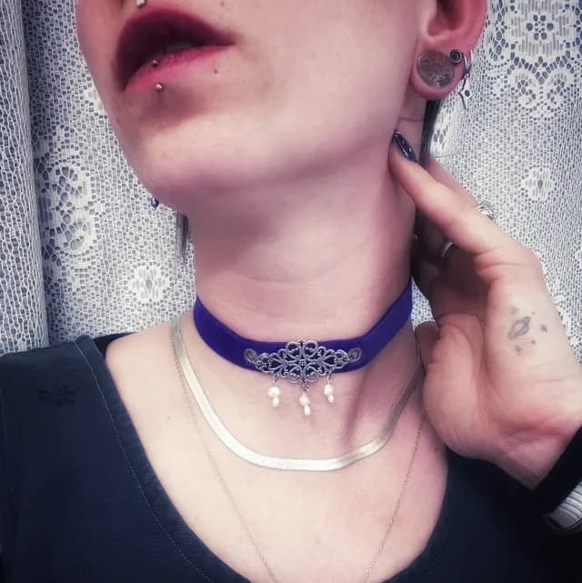 Ras de cou en velours bleu roi orné d'une pièce en métal ouvragé et de perles blanches naturelles.