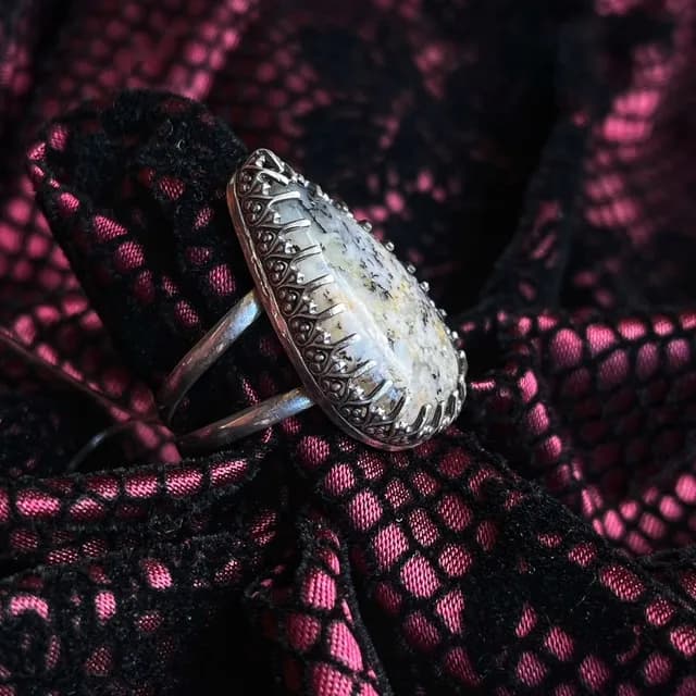 Vue latérale de la bague montrant la monture travaillée en argent et l'anneau double.